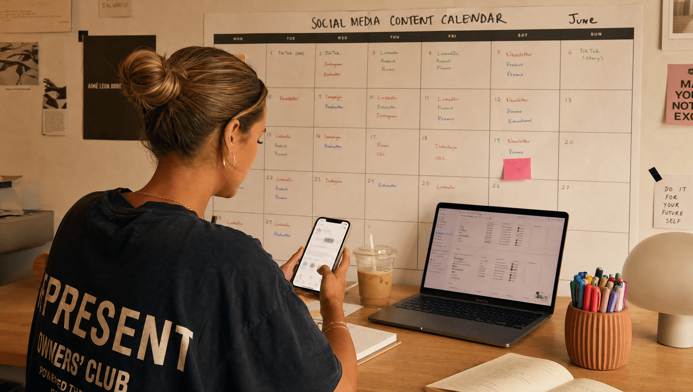 Social media manager scheduling content with a printed content calendar and scheduling app