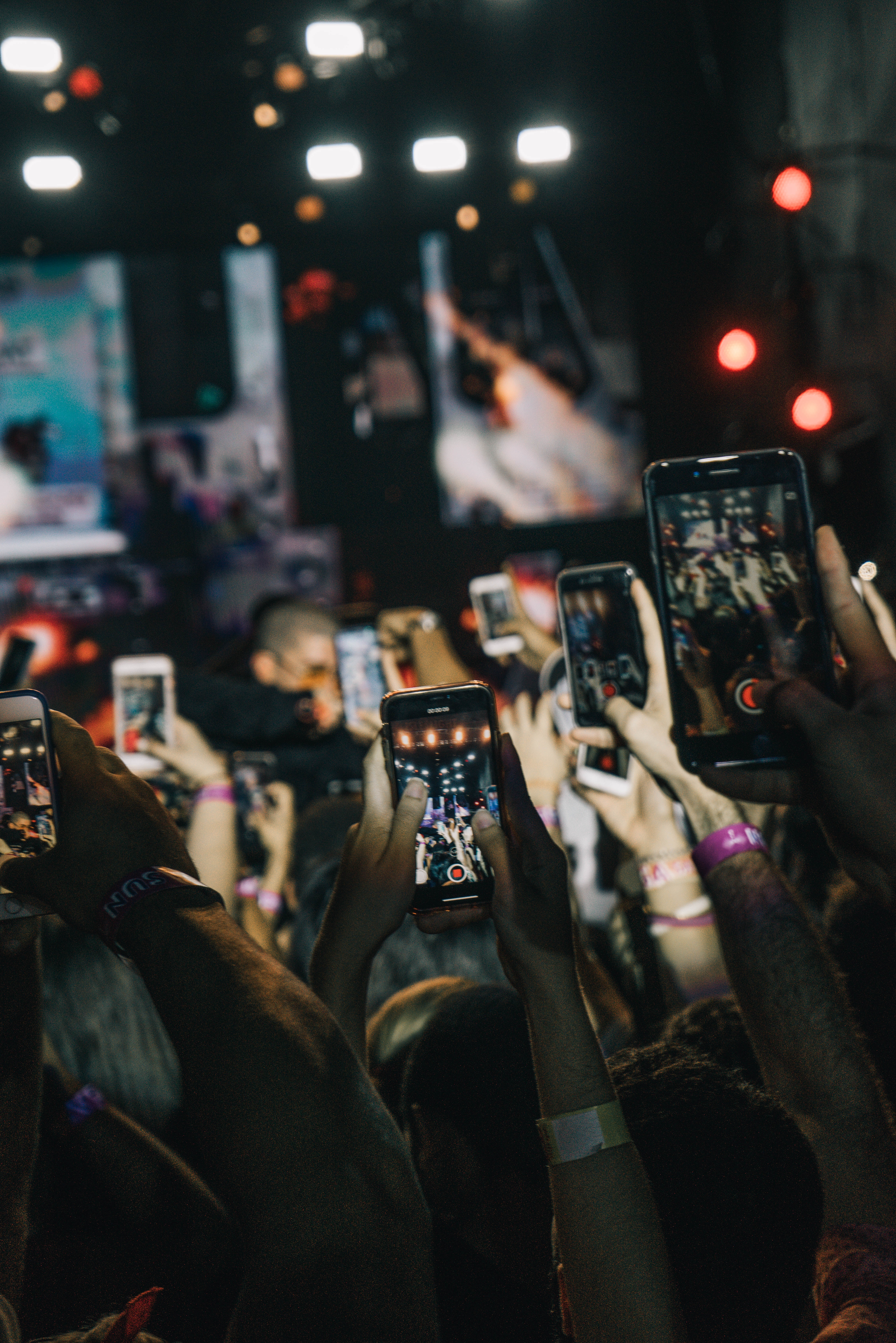 People holding their phones up at a concert